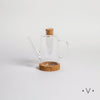 Image of Aceitera de vidrio cilíndrica con base de corcho.