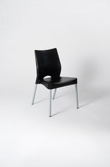 Silla Malba de plástico negro con patas microtexturadas.