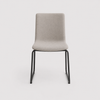 Image of Silla quina tapizada en color beige base trineo con patas negras o blancas.
