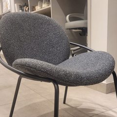 Sillón Vila tapizado en tela con patas de hierro negro.