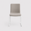 Image of Silla quina tapizada en color beige base trineo con patas negras o blancas.